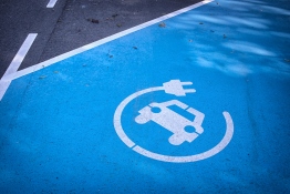 The image shows a parking area with a charging station for electric cars being marked.